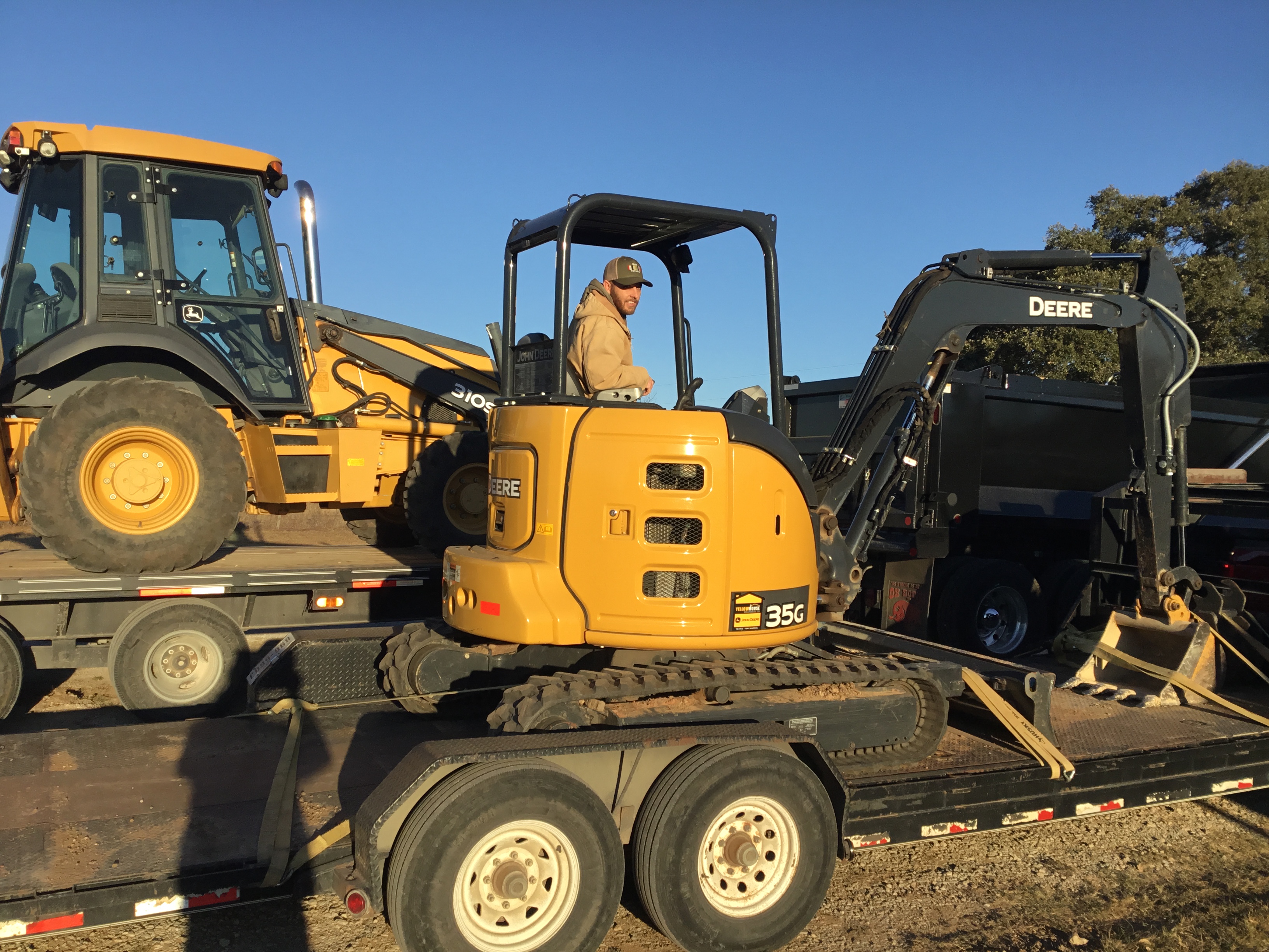 JD's Septic Service John Deere 35G mini excavator on trailer at job site