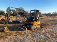 Chris Yarbrough operating a John Deere mini excavator on a Central Texas job site