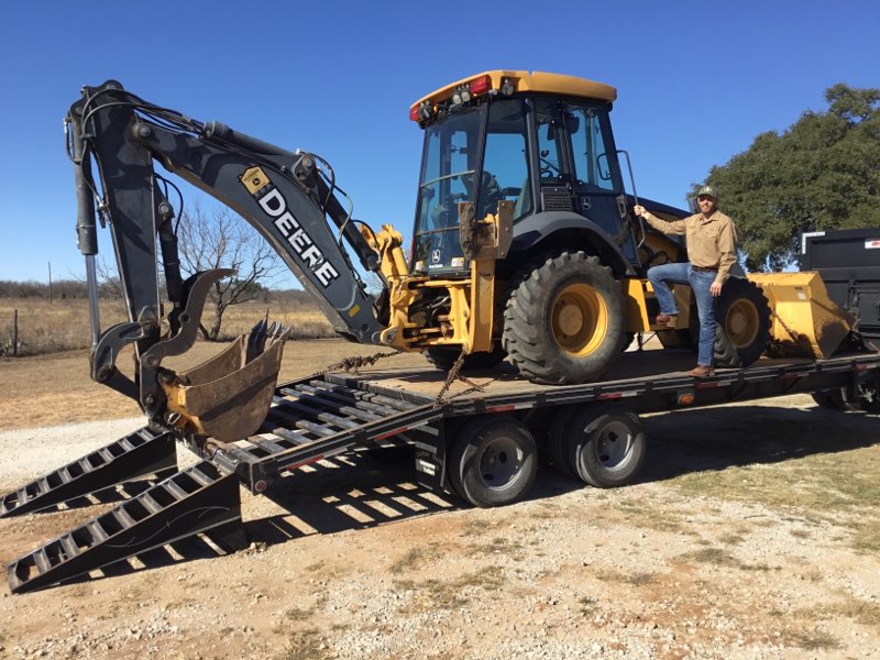 Chris Yarbrough with JD's John Deere backhoe loaded on trailer